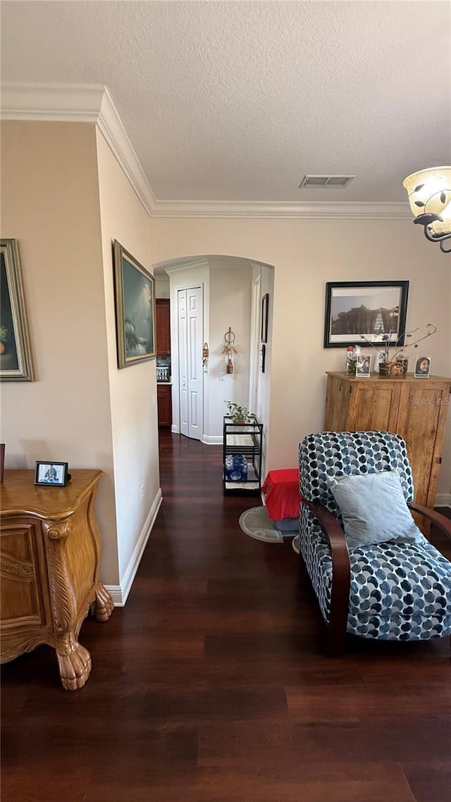 corridor with crown molding, dark hardwood / wood-style floors, and a textured ceiling