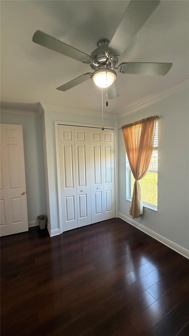 unfurnished bedroom featuring dark hardwood / wood-style flooring, ornamental molding, a closet, and ceiling fan