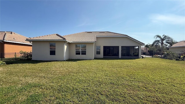 back of house with a sunroom and a yard