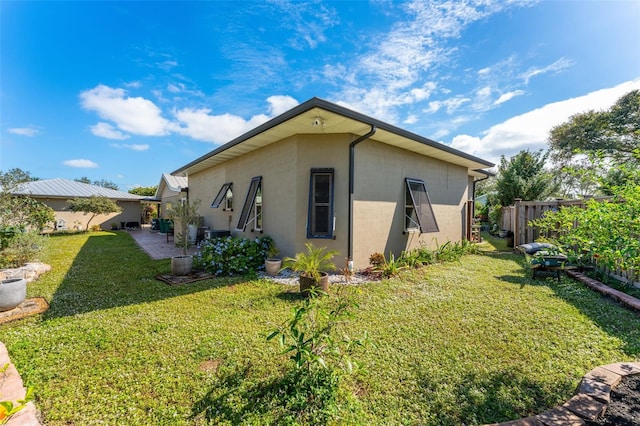 view of home's exterior with a lawn and a patio area