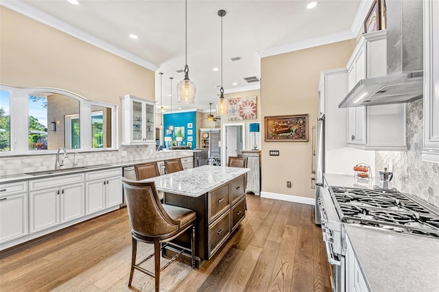 kitchen with wall chimney exhaust hood, a center island, and white cabinets