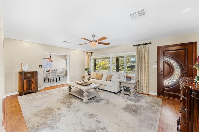 living room featuring ceiling fan and parquet flooring