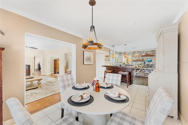 dining area featuring crown molding and light parquet flooring