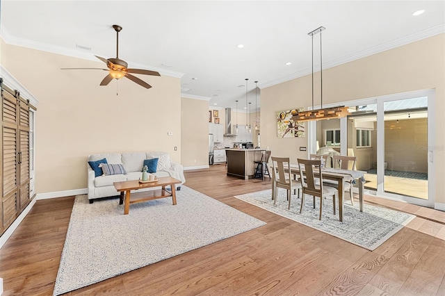 living room featuring ceiling fan, ornamental molding, hardwood / wood-style floors, and a high ceiling