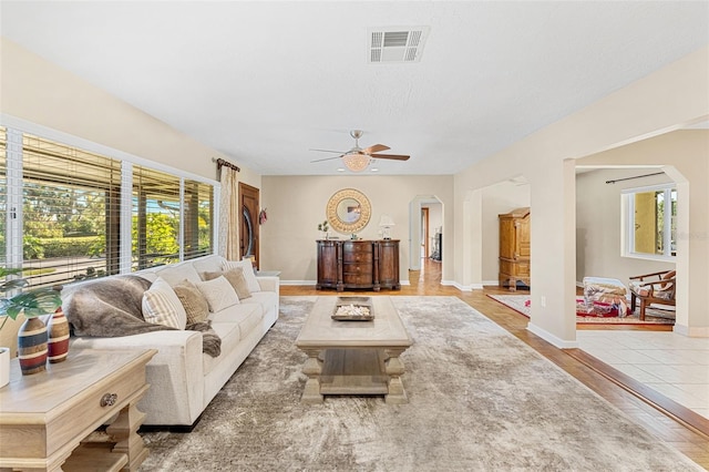 living room with ceiling fan, wood-type flooring, and a textured ceiling