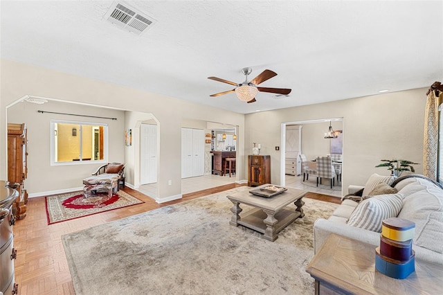 living room featuring parquet floors, ceiling fan, and a textured ceiling