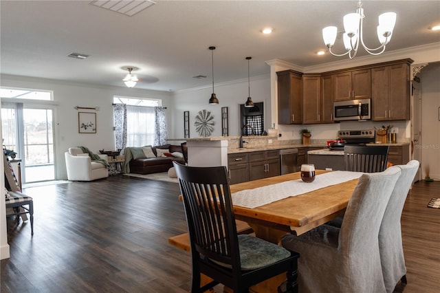 dining space featuring an inviting chandelier, sink, dark hardwood / wood-style flooring, and ornamental molding