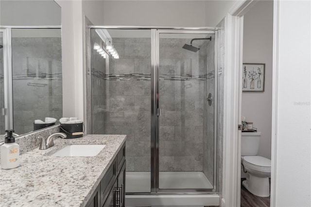 bathroom with vanity, an enclosed shower, hardwood / wood-style flooring, and toilet