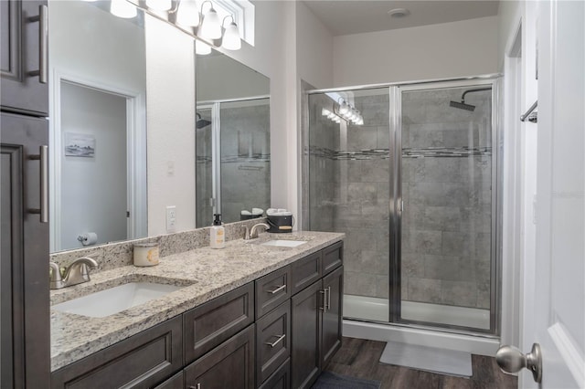 bathroom featuring vanity, wood-type flooring, and a shower with door