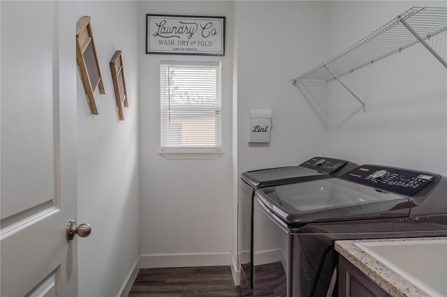 clothes washing area featuring dark hardwood / wood-style flooring, sink, and washer and clothes dryer