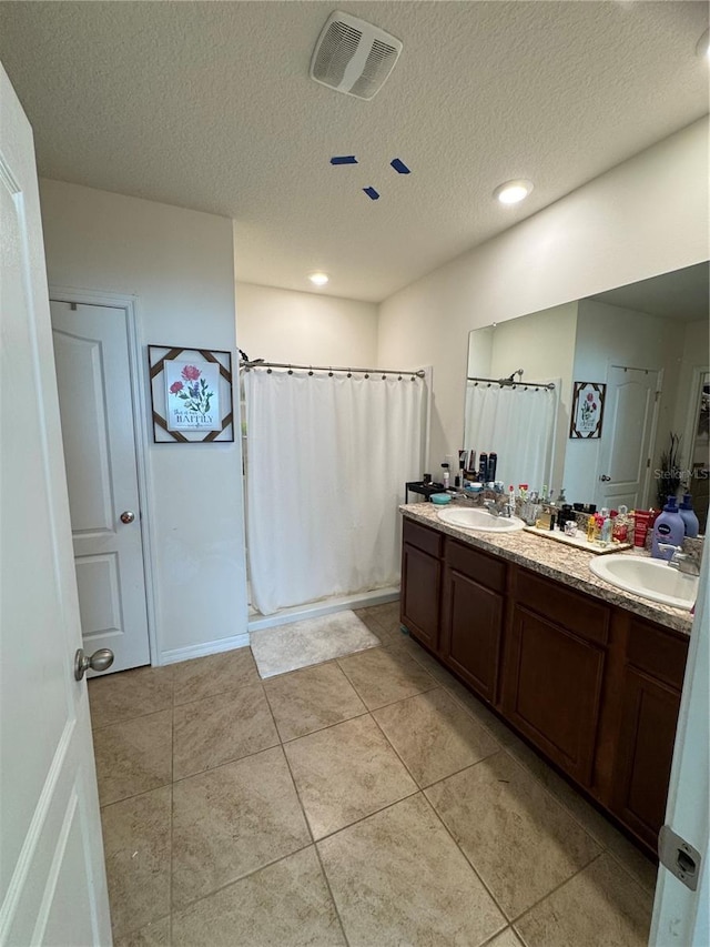 bathroom with vanity, tile patterned floors, and a textured ceiling