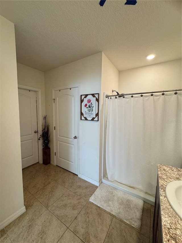 bathroom featuring vanity, a shower with curtain, tile patterned floors, and a textured ceiling