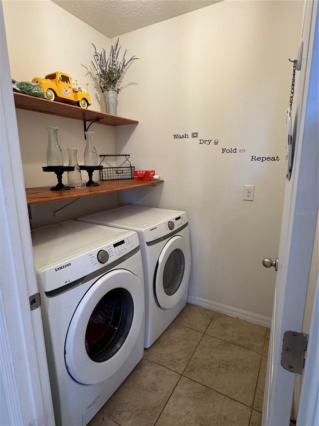 clothes washing area featuring light tile patterned floors, a textured ceiling, and independent washer and dryer