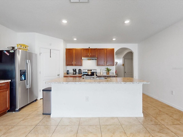 kitchen featuring appliances with stainless steel finishes, a center island with sink, and under cabinet range hood