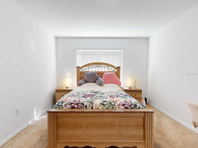 bedroom with light carpet and baseboards