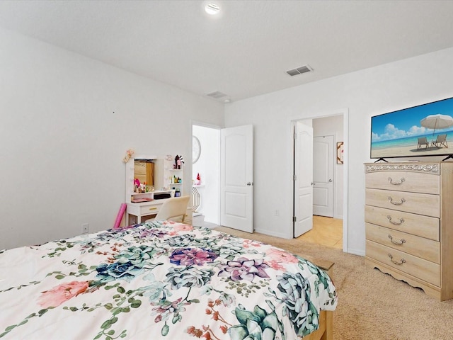 bedroom with light carpet, visible vents, and baseboards