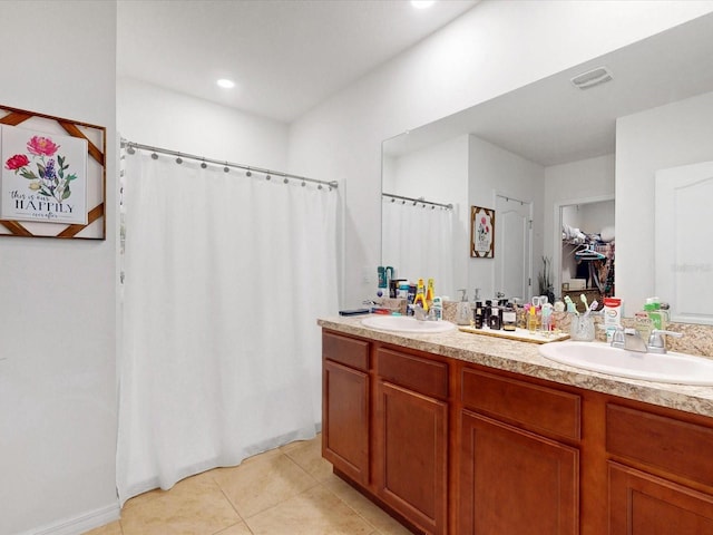 full bathroom with tile patterned flooring, a spacious closet, visible vents, and a sink