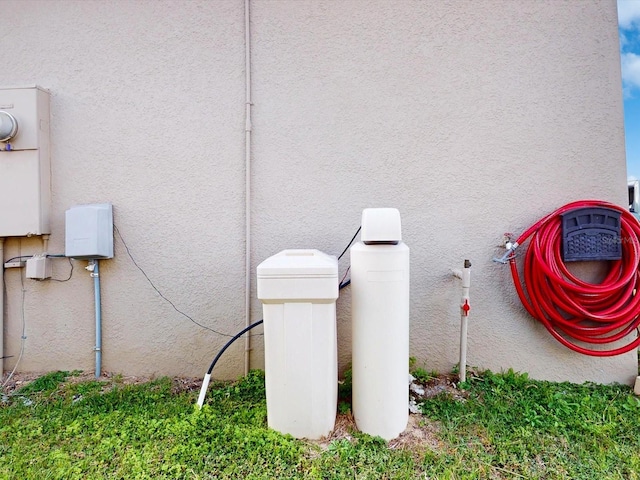 exterior details featuring electric meter and stucco siding