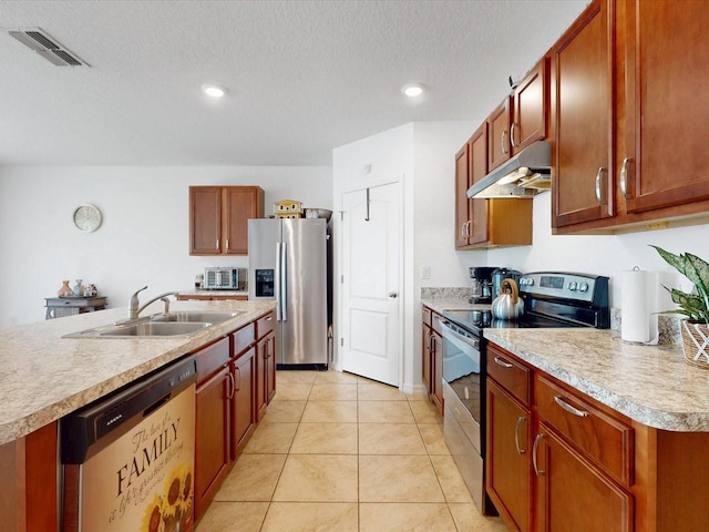 kitchen featuring appliances with stainless steel finishes, visible vents, light countertops, and under cabinet range hood