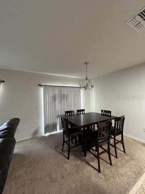 dining room with carpet floors and a chandelier