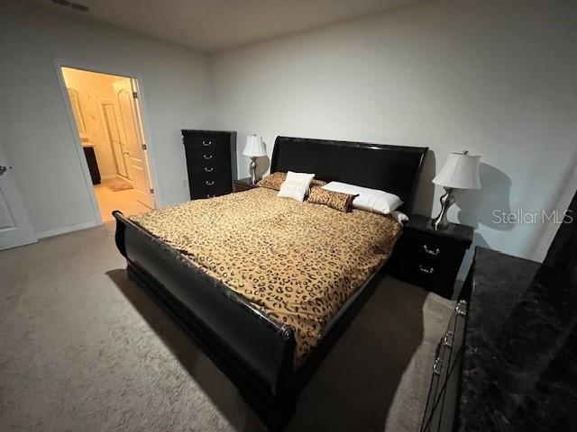 carpeted bedroom featuring ensuite bath