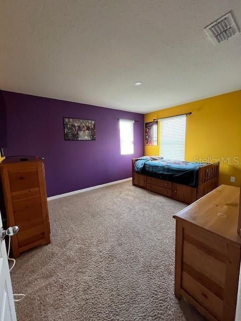 bedroom featuring carpet and a textured ceiling