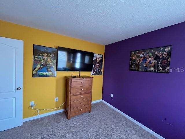 bedroom featuring carpet and a textured ceiling