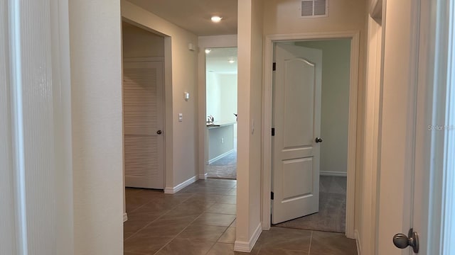 hall with dark tile patterned flooring