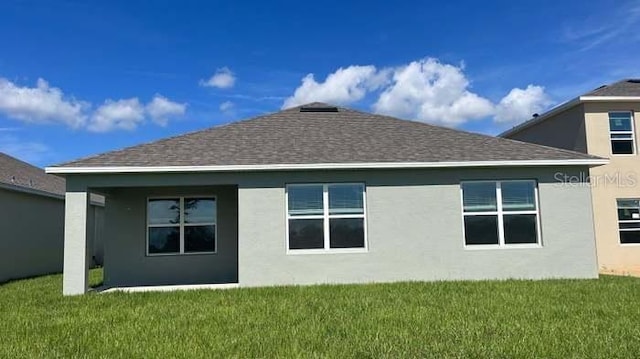 rear view of property featuring a lawn