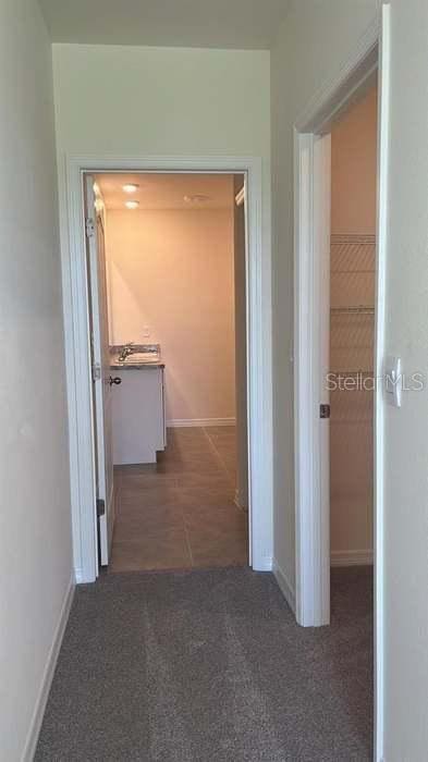 hallway featuring dark colored carpet