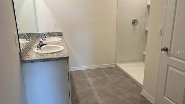 bathroom featuring tile patterned flooring, vanity, and a shower