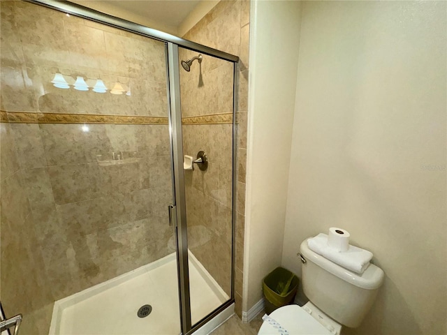 bathroom with toilet and a shower with door