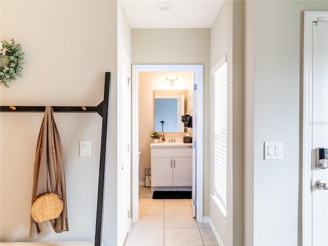 hallway with light tile patterned floors and sink