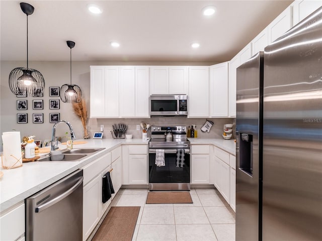 kitchen featuring sink, light tile patterned floors, stainless steel appliances, and white cabinets