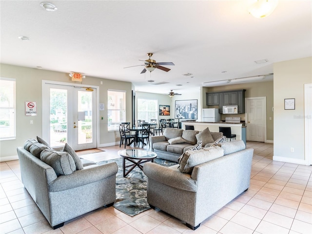 tiled living room with ceiling fan and french doors