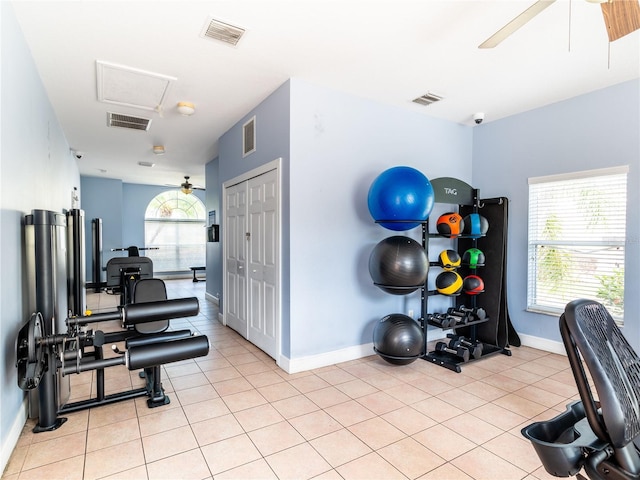 exercise area featuring a healthy amount of sunlight, light tile patterned floors, and ceiling fan