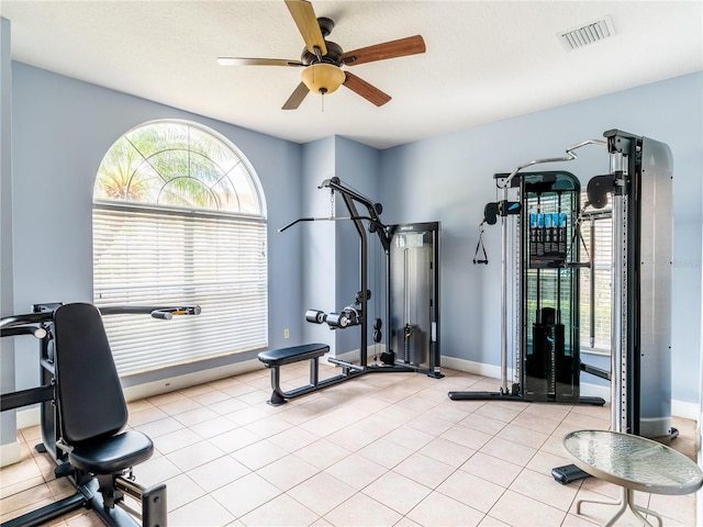 workout area featuring light tile patterned flooring, a textured ceiling, and ceiling fan