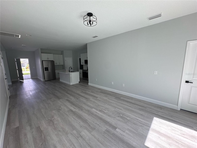 104 Australian Dr, Rotonda West, FL 33947 - unfurnished living room featuring baseboards and wood finished floors