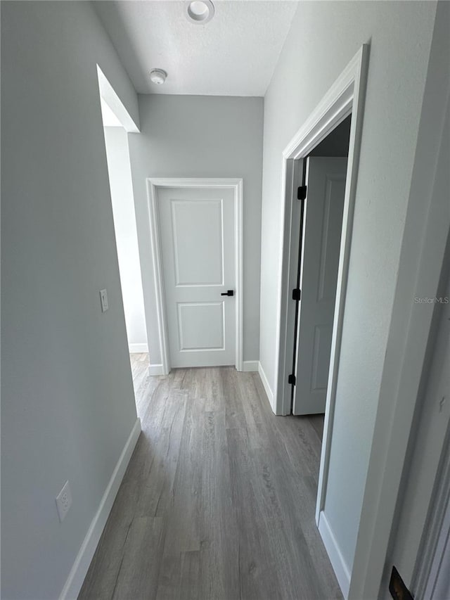 104 Australian Dr, Rotonda West, FL 33947 - corridor with wood finished floors and a textured ceiling