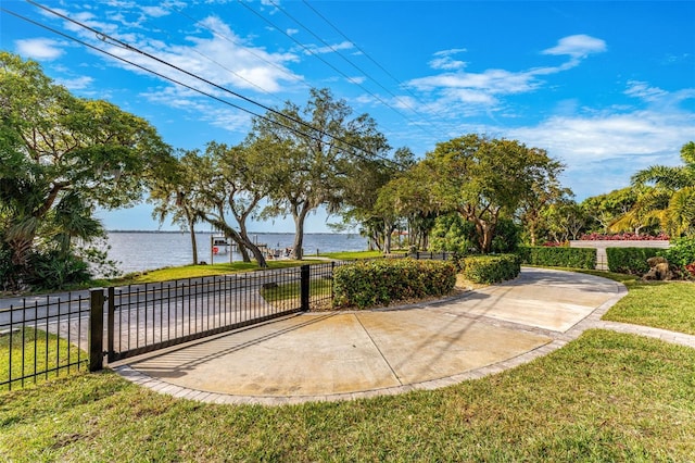 exterior space with a yard, a water view, and fence