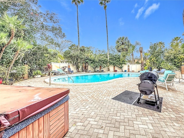 view of pool with a hot tub and a patio area