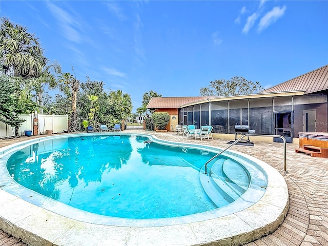 view of swimming pool featuring a sunroom, a patio area, and a jacuzzi