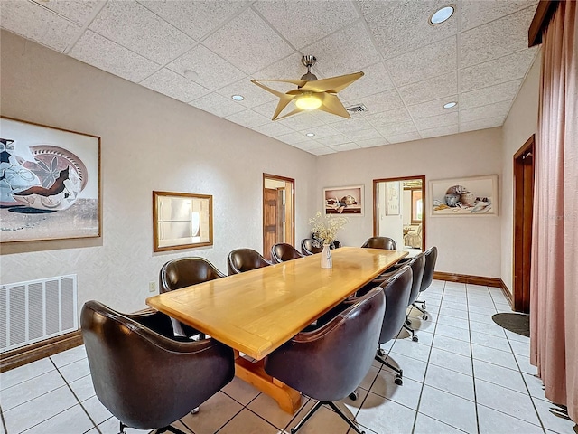 tiled dining area featuring ceiling fan and a paneled ceiling