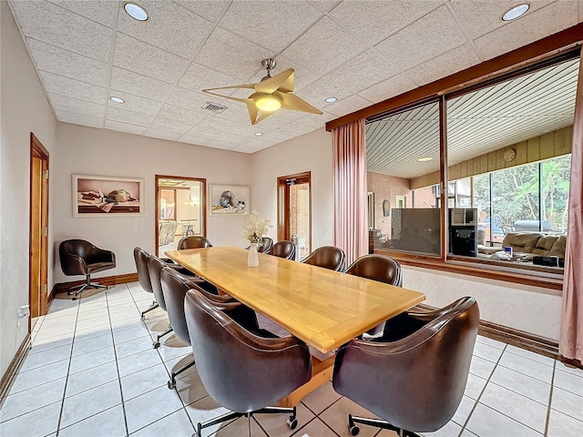 tiled dining area with a paneled ceiling and ceiling fan