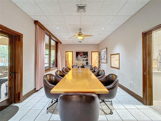 tiled dining room with a paneled ceiling and ceiling fan