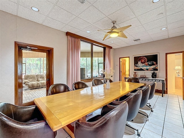 dining area featuring a paneled ceiling, ceiling fan, and light tile patterned floors