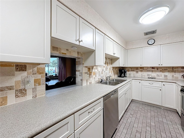 kitchen with sink, backsplash, white cabinets, and dishwasher