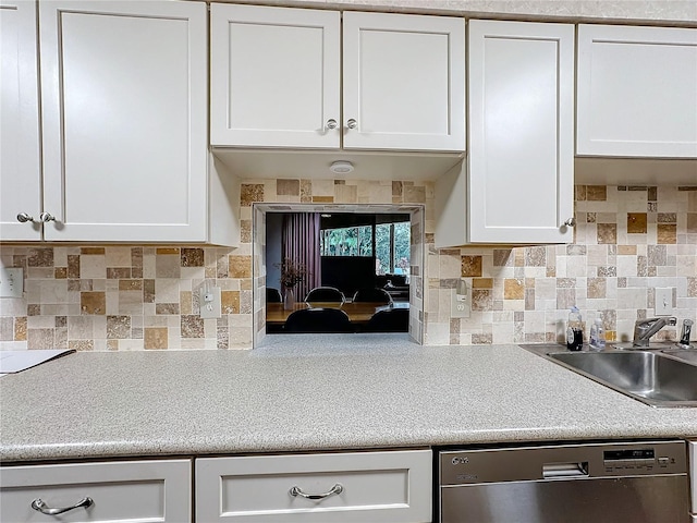 kitchen with backsplash, dishwasher, sink, and white cabinets