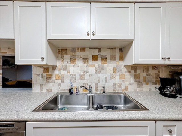 kitchen featuring tasteful backsplash, white cabinetry, dishwasher, and sink