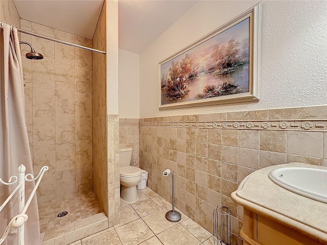 bathroom featuring tile walls, vanity, tile patterned floors, toilet, and walk in shower